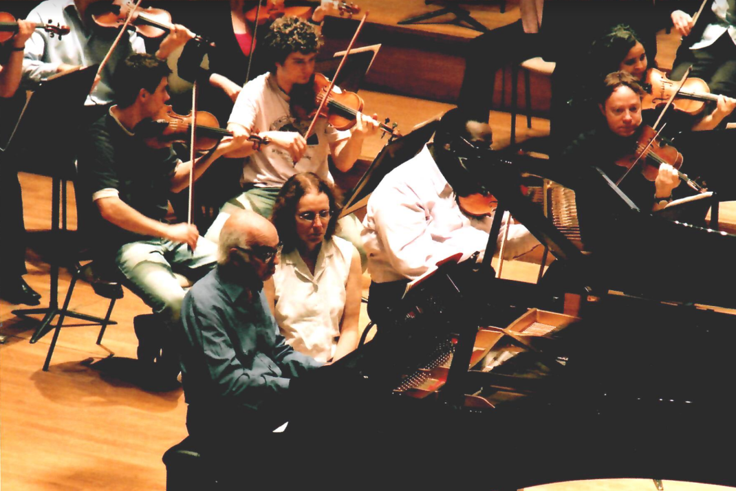 An orchestra in rehearsal with a piano soloist